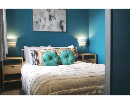 1 dormitorio azul con 1 cama con paredes azules en Central Belfast Apartments The Village House, en Belfast