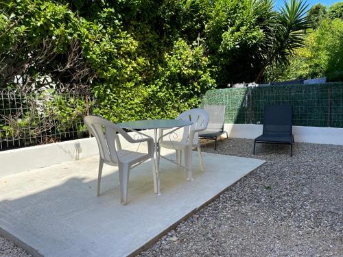 two chairs and a table and a table and chairs at Appt 1 chambre jardin parking in Narbonne