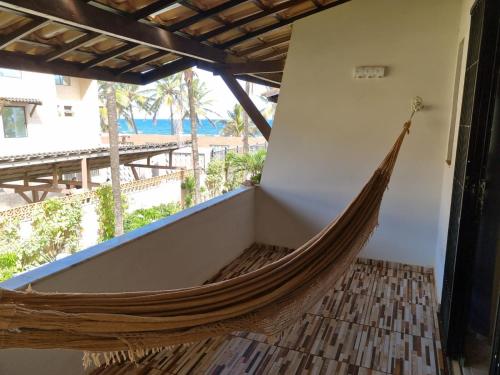 a hammock in a room with a view of the beach at Brisa do Mar Village in Salvador