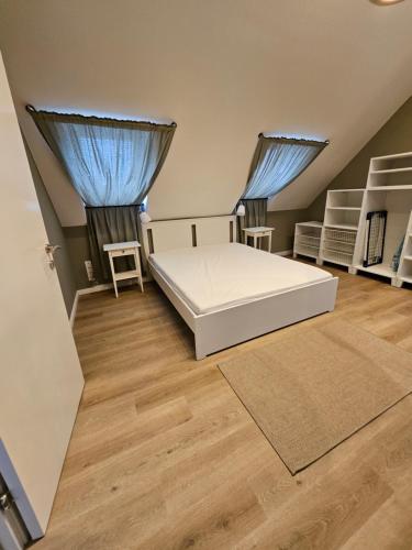 a bedroom with a white bed and two windows at Best Prater Apartments in Vienna