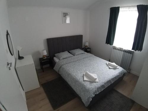 a bedroom with a bed with two white towels on it at Studio Apartment Lenchy in Zagreb