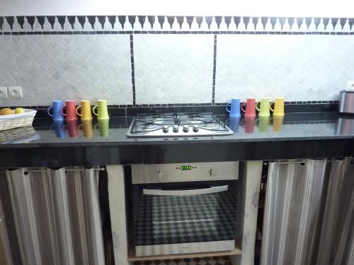 a kitchen with a stove top oven under a counter at DAR SEFFAH au cœur de la Médina in Fès