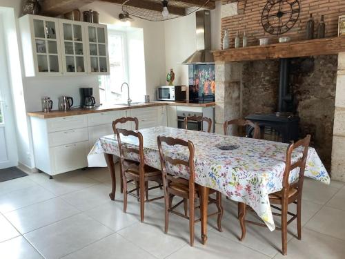 une cuisine avec une table, des chaises, une table et un comptoir dans l'établissement Propriété de campagne au calme, à Le Bourdeix