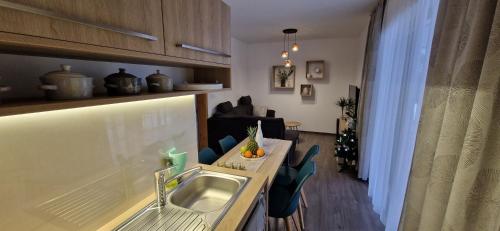 a kitchen with a sink and a living room at ZORE JASNÁ Apartments in Demanovska Dolina