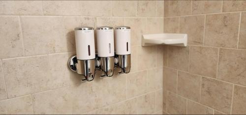 a bathroom wall with a row of white bottles at Sunny apartments in Bayburt