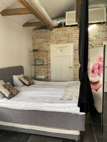 a bed in a room with a brick wall at Villa Deluxe at Brohuspark in Lomma