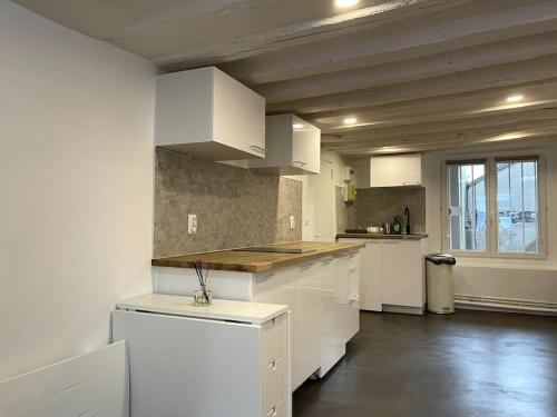cocina con armarios blancos y encimera en Heart of Paris Apartment en París
