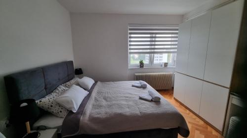 a small bedroom with a bed and a window at Apartman Nora in Čakovec
