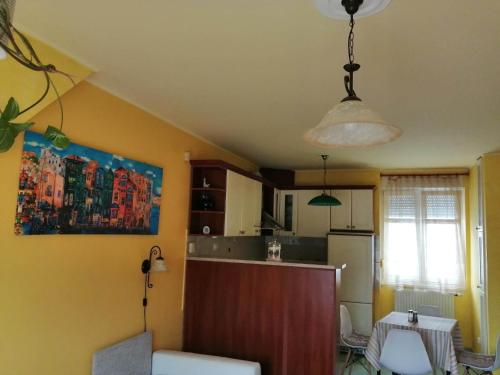 a kitchen with yellow walls and a table and a light at GingerBED Apartman in Kaposvár