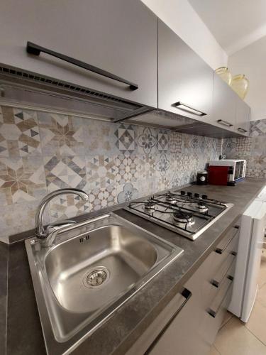 a kitchen with a stainless steel sink and a stove at la chiocciola in Mesagne