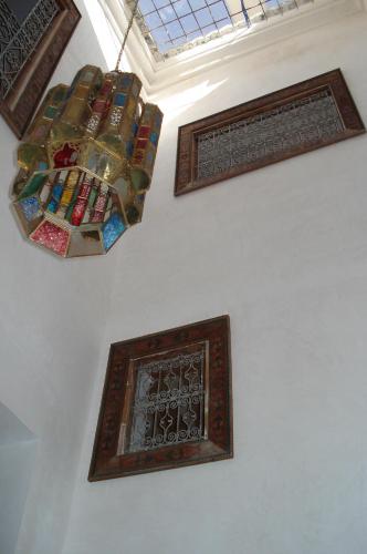 a room with a chandelier and some framed windows at DAR SEFFAH au cœur de la Médina in Fès