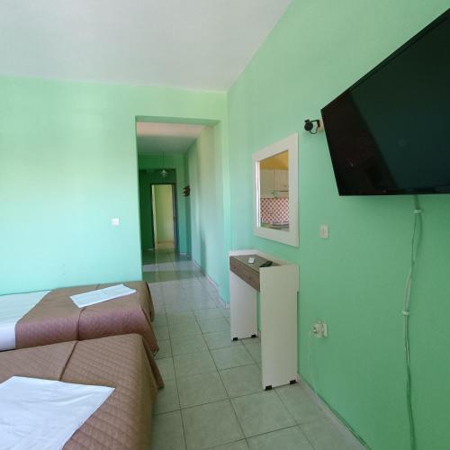 a room with two beds and a flat screen tv at Casa Angelina in Polychrono