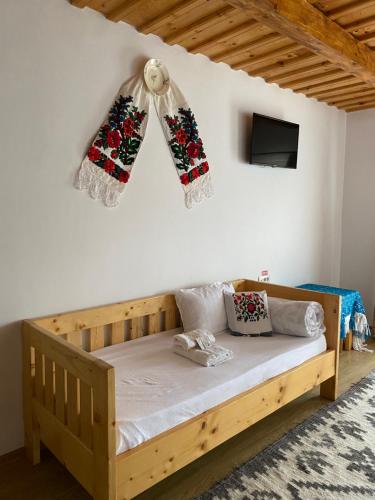 a bedroom with a wooden bed and a tv at Popas in Breb in Breb