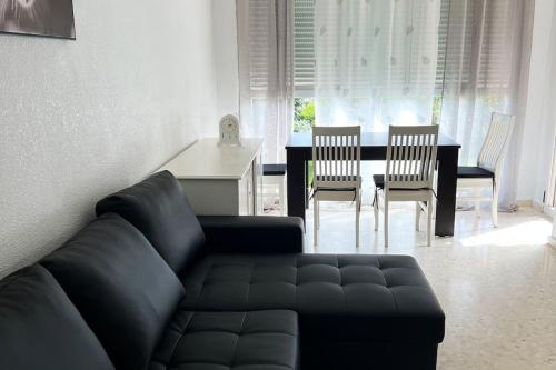 een woonkamer met een bank, een tafel en stoelen bij Puerto Romano Denia in Denia