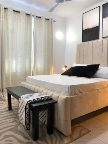 a bedroom with a large bed and a bench at C.leslie_homes2 in Bamburi