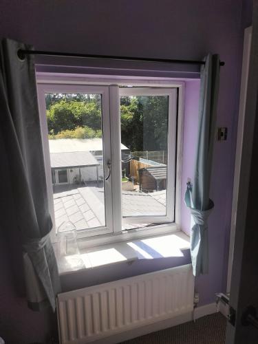 una ventana en una habitación con paredes y cortinas moradas en Private room en Wrexham