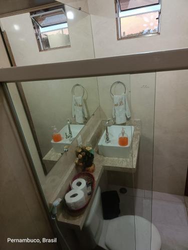 a bathroom with two sinks and a toilet at Florcamará POUSADA in Camaragibe