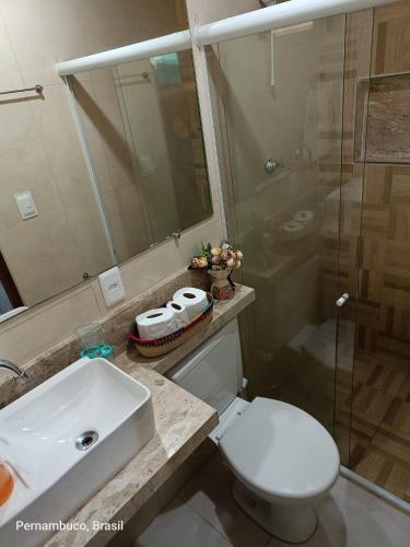 a bathroom with a toilet and a sink and a shower at Florcamará POUSADA in Camaragibe