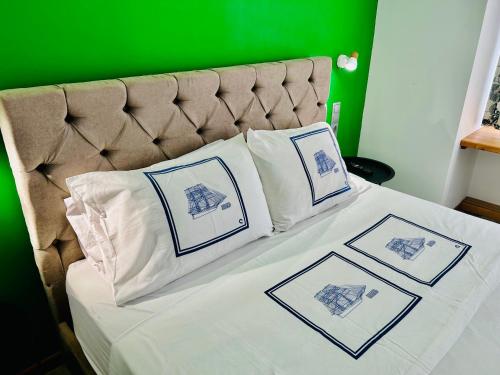 a bed with four pillows and a green wall at CASA VERDE di Giorgio 10 mins walk from Piraeus port in Piraeus