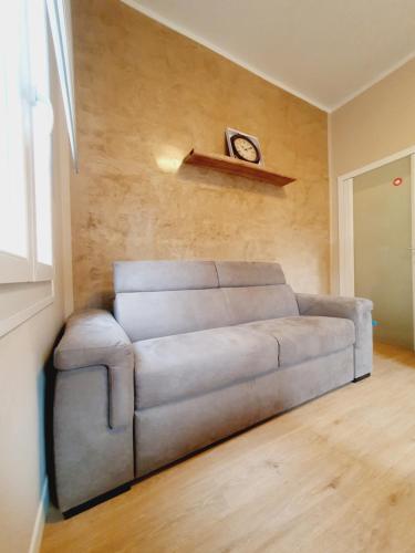 a couch in a living room with a clock on the wall at Casa Tiffany in Vicenza