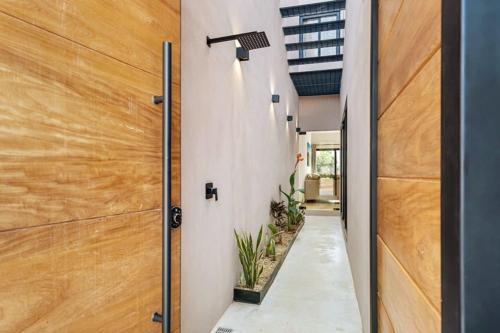 a wooden pivot door in a house with plants at Quiet 3BR Villa in La Punta, Private Pool! in Puerto Escondido