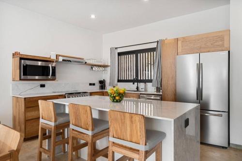 a kitchen with a large island with chairs and a refrigerator at Quiet 3BR Villa in La Punta, Private Pool! in Puerto Escondido
