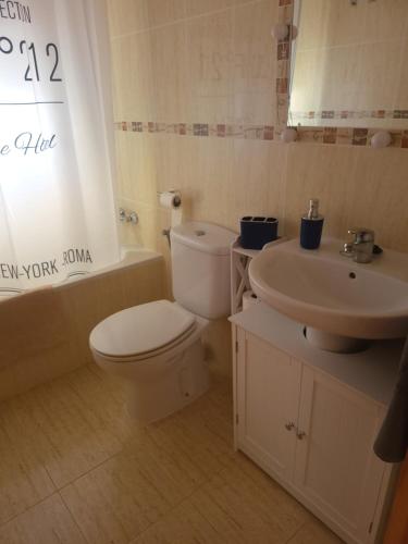 a bathroom with a toilet and a sink at Chalet Edy con piscina in Peniscola