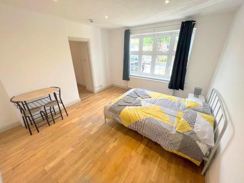 una camera con letto, tavolo e sedia di Studio Apartments in Sutton (South London) a Cheam