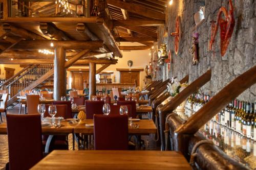 a restaurant with wooden tables and chairs and wine racks at Etna Quota Mille Boutique Hotel, Typical Sicilian Food & Wine in Randazzo