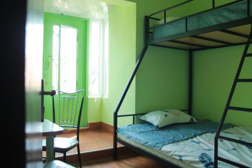 a bedroom with a bunk bed and a chair at Umbrella Kutaisi - Guest house in Kutaisi