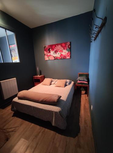 um quarto com uma cama e um quadro na parede em Numéro 12, appartement douillet em Montauban
