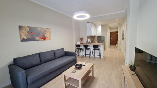Una sala de estar con un sofá azul y una mesa. en KYANA luxury, en Tesalónica