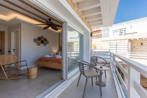 a room with a balcony with a bed and chairs at Kalkan Saray Suites Hotel in Kalkan