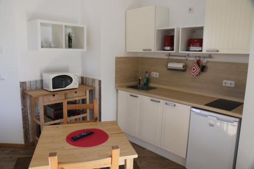 una piccola cucina con tavolo in legno e tavolo in legno di FeWo-Roggenring-Leipzig a Lipsia