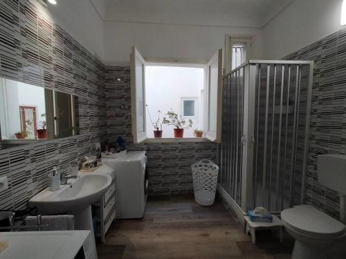 een badkamer met een wastafel, een toilet en een raam bij Loggia58 in Trapani