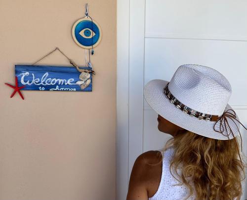 a woman wearing a white hat next to a welcome to america sign at AMMOS Beach apartment in Sidari