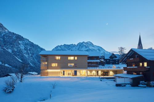a building in the snow with a mountain in the background at Tinn Naturchalet in Mittelberg
