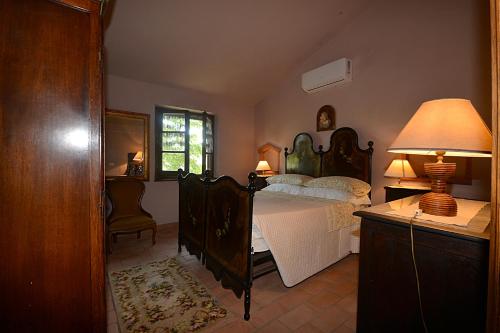 a bedroom with a bed and a lamp on a dresser at La Casina di Sarteano in Sarteano