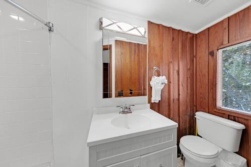 a bathroom with a sink and a toilet and a mirror at Sealake Cottage in Santa Rosa Beach