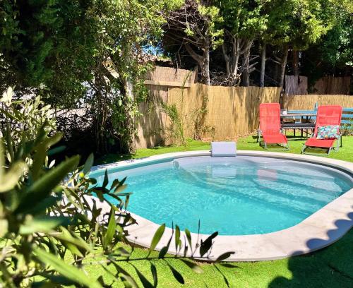 mały basen na dziedzińcu z dwoma czerwonymi krzesłami w obiekcie Calme et Intimité proche Avignon Piscine options au choix privée ou partagée de juin à octobre w mieście Morières-lès-Avignon