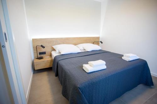 a bedroom with a blue bed with towels on it at Villa Favi in Pakoštane