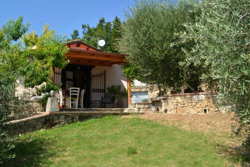 a house with a porch and a stone wall at La Casina di Sarteano in Sarteano