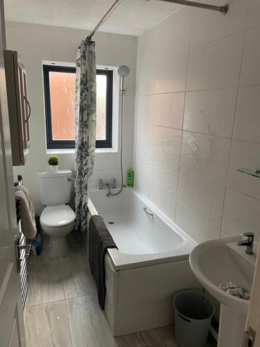 a bathroom with a tub and a toilet and a sink at 3 bedroom home in Nottage, Porthcawl in Nottage