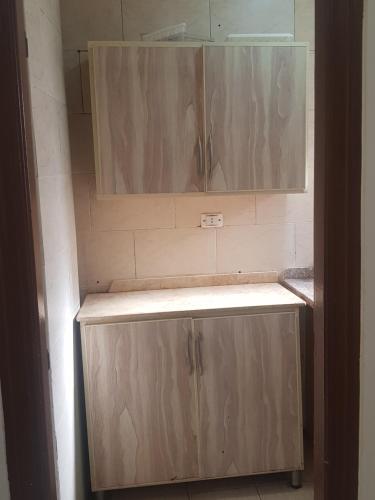 a bathroom with a wooden cabinet and a mirror at شارع اسكندرية in Marsa Matruh