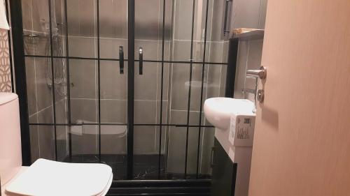 a bathroom with a shower with a toilet and a sink at Grand royal hotel in Gümüşyaka