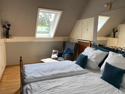 a bedroom with two beds and a chair and a window at Gästehaus Villa Kreativ Susanne Lay in Bad Münder am Deister