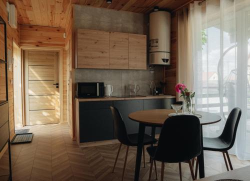 een keuken en eetkamer met een tafel en stoelen bij MAZURY LAKE RESORT in Wydminy