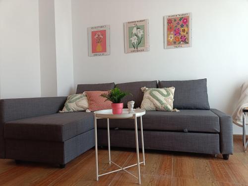 - un canapé gris dans le salon avec une table dans l'établissement Apartamento Happy Street, à Socuéllamos