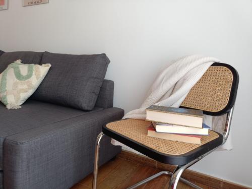 une table de chevet avec des livres à côté d'un canapé dans l'établissement Apartamento Happy Street, à Socuéllamos