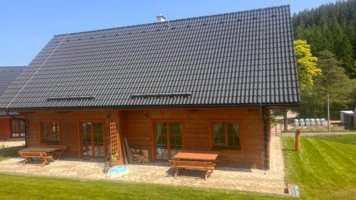 a log cabin with a picnic table and benches at Apartmány Orlice in Červená Voda